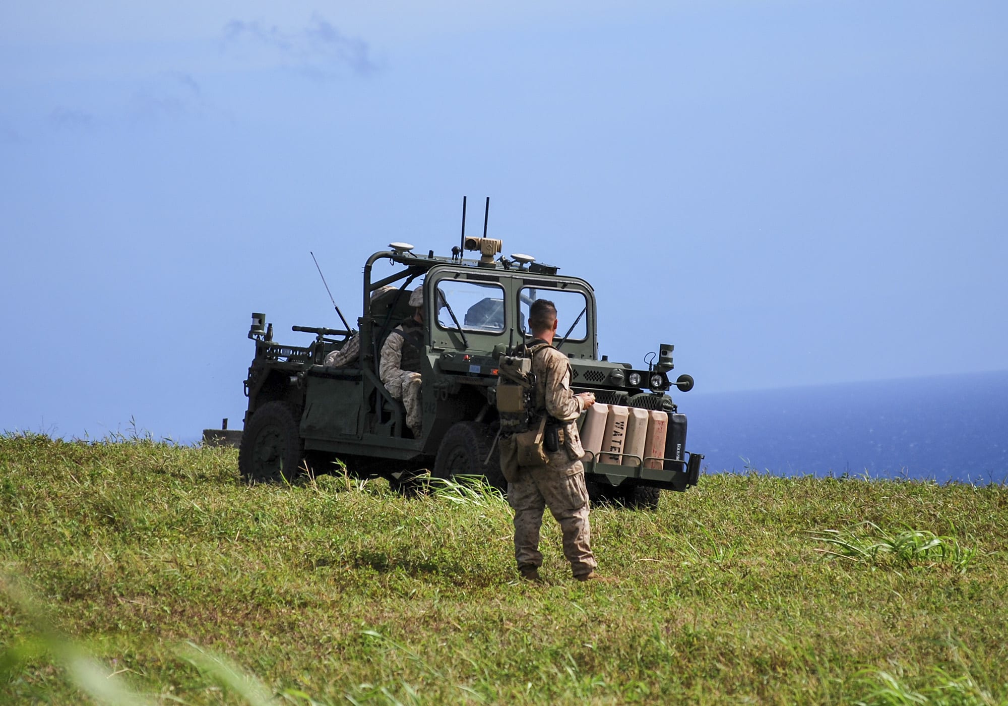 Soldiers working with a unmanned vehicle The Ground Unmanned Support Surrogate (GUSS).