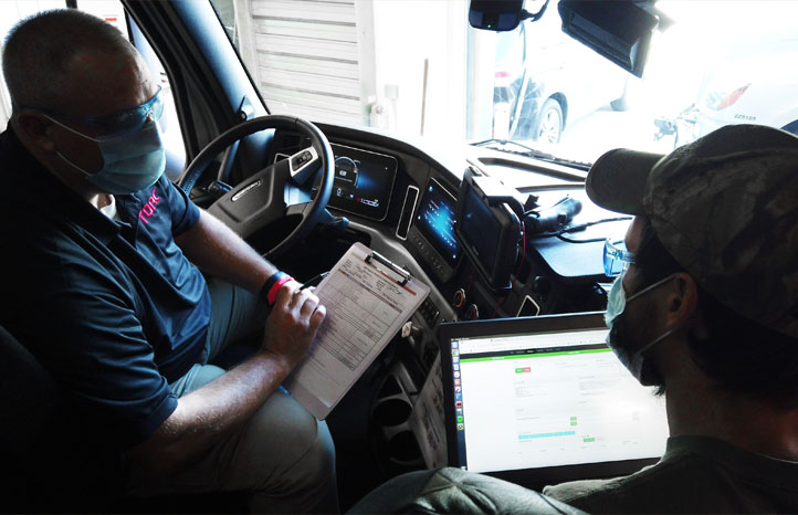 Torc employees looking over testing notes in a vehicle