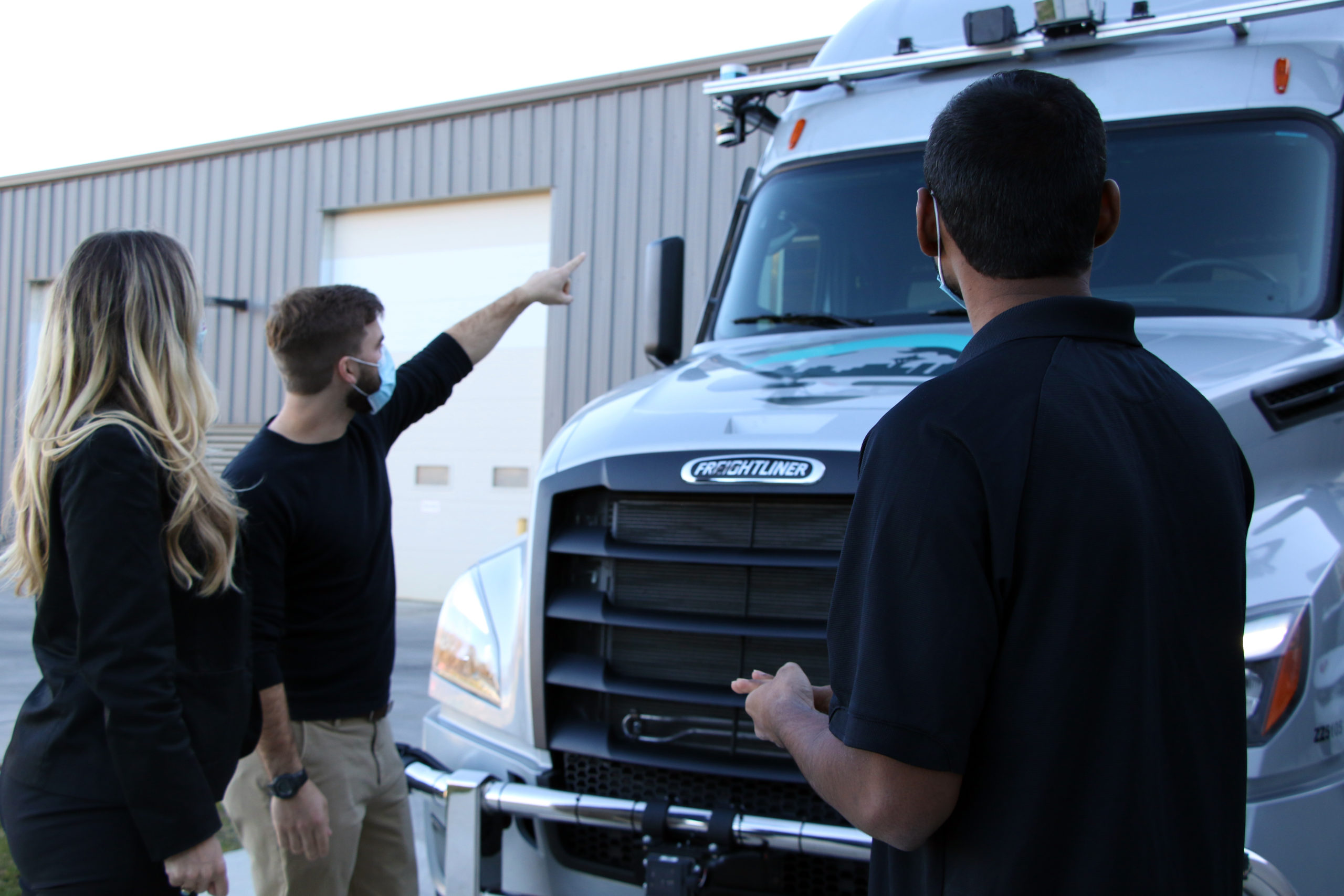 Vehicle Testers perform a walkaround of a Torc truck before testing