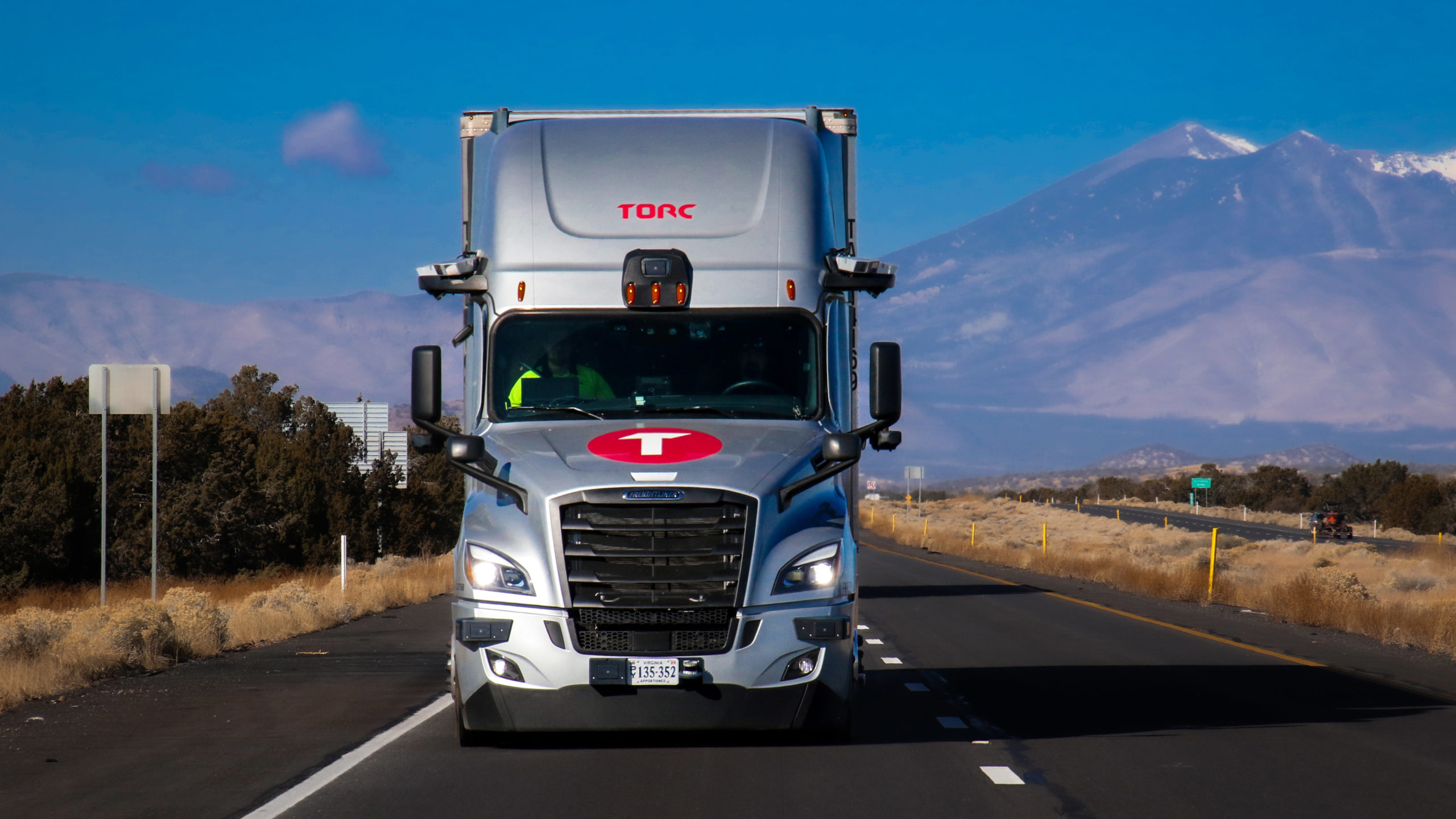 Torc autonomous Cascadia Freightliner in Arizona on the highway, mountain in the background