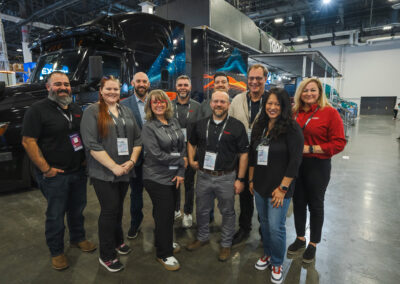 Torc Robotics employees pose in front of a booth at Manifest 2025.