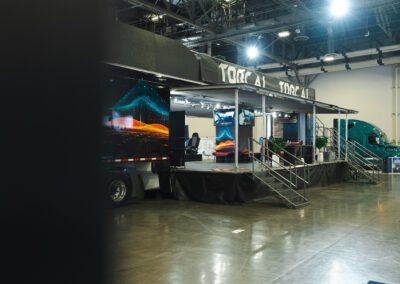 Torc Robotics' booth at Manifest: a truck trailer broken out with places to sit, watch videos about Torc, and talk to Torc employees.